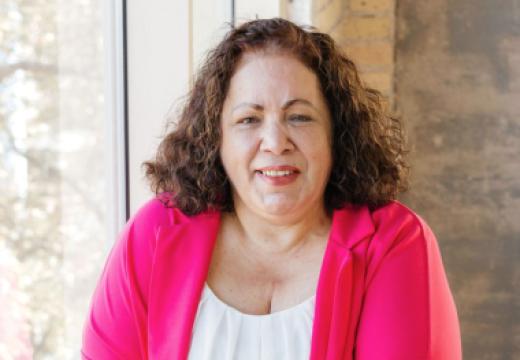 Sharon Hackney smiling into at camera with an industrial background